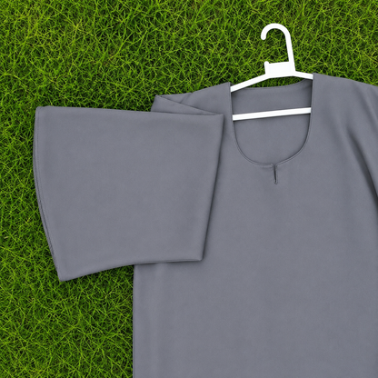 A gray short-sleeve tunic top with a split neckline, displayed on a white hanger over a green grass background.